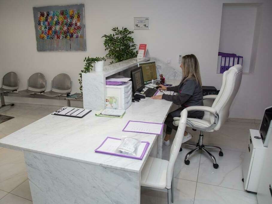 Assistante dentaire sur ordinateur devant une salle d’attente au cabinet dentaire de Marignane